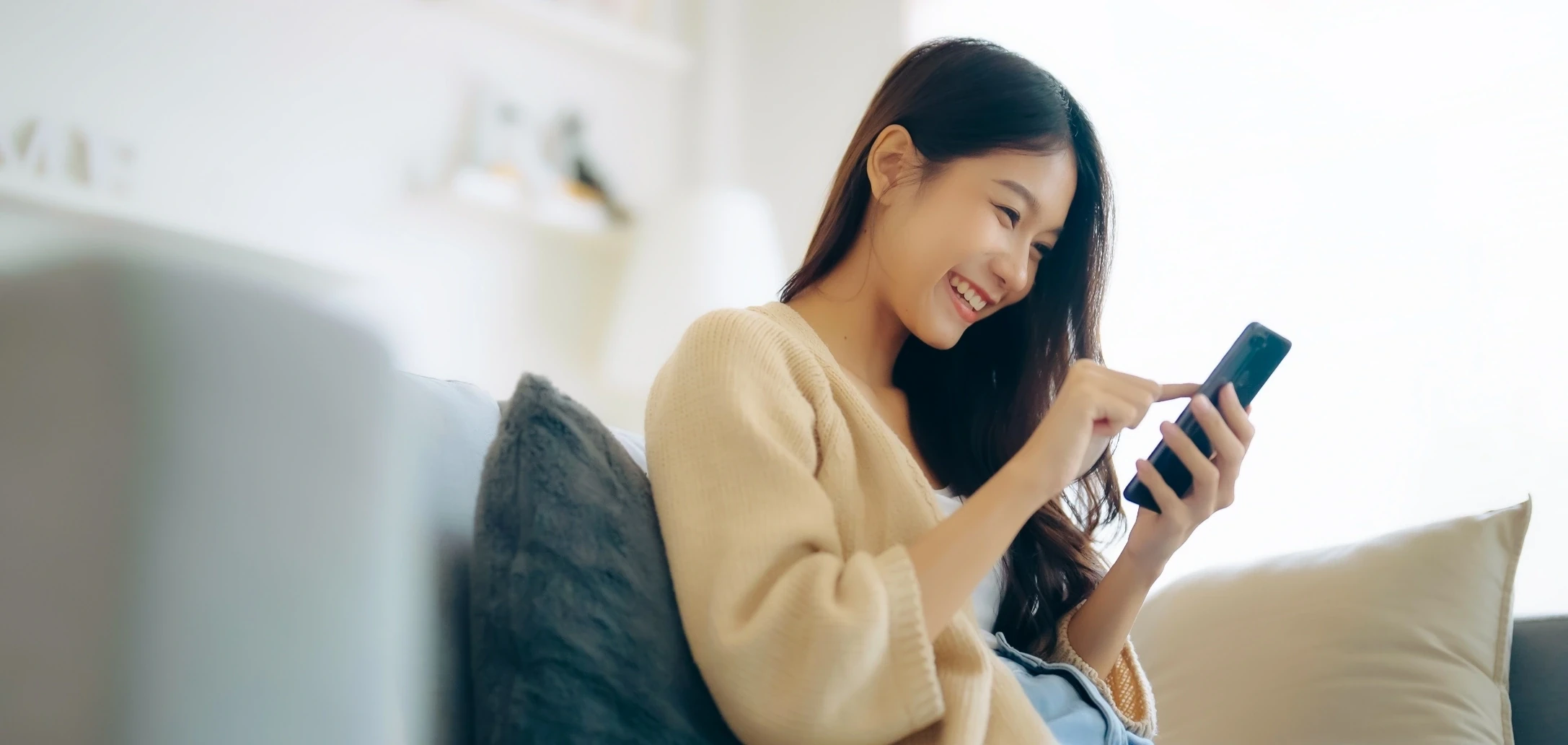 happy young woman using her smartphone to book an appointment online