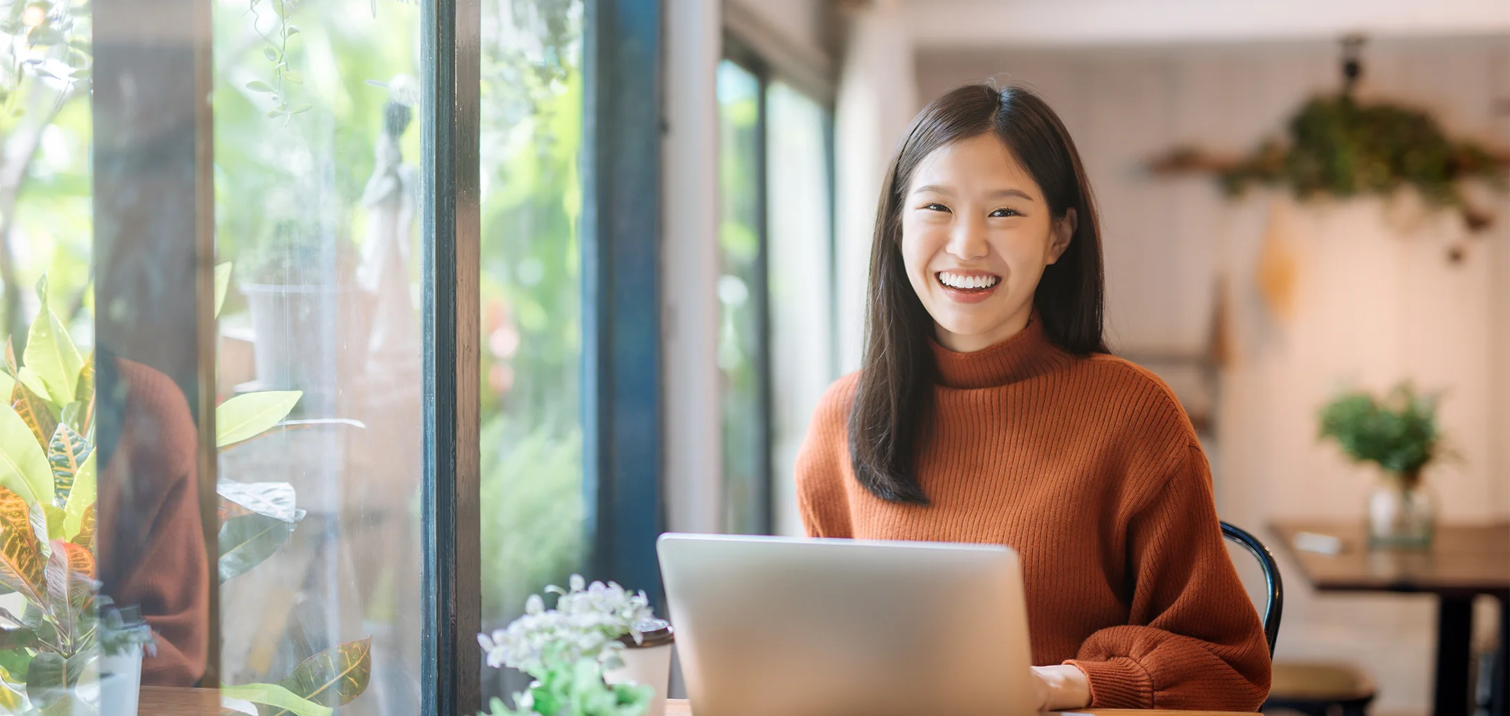 joyful woman using computer looking at camera