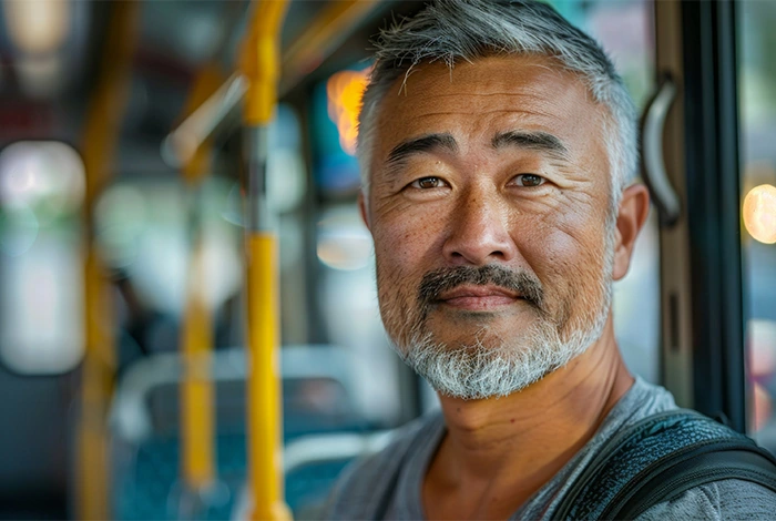 portrait of mature asian man riding on city bus