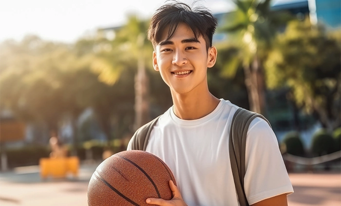 young man smiling holding basketball